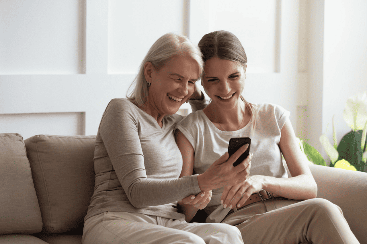mother and daughter laugh at phone